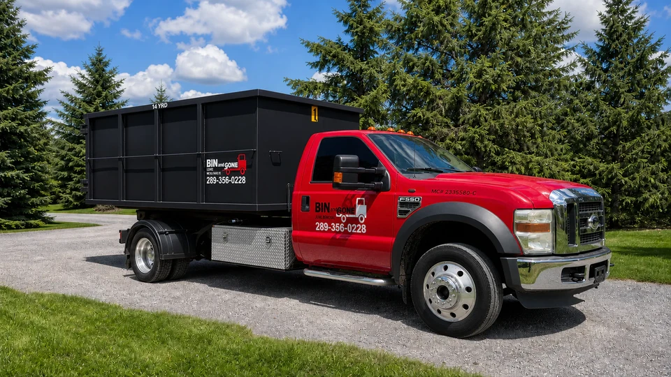 Bin and Gone red truck carrying a black disposal bin, photographed outdoors